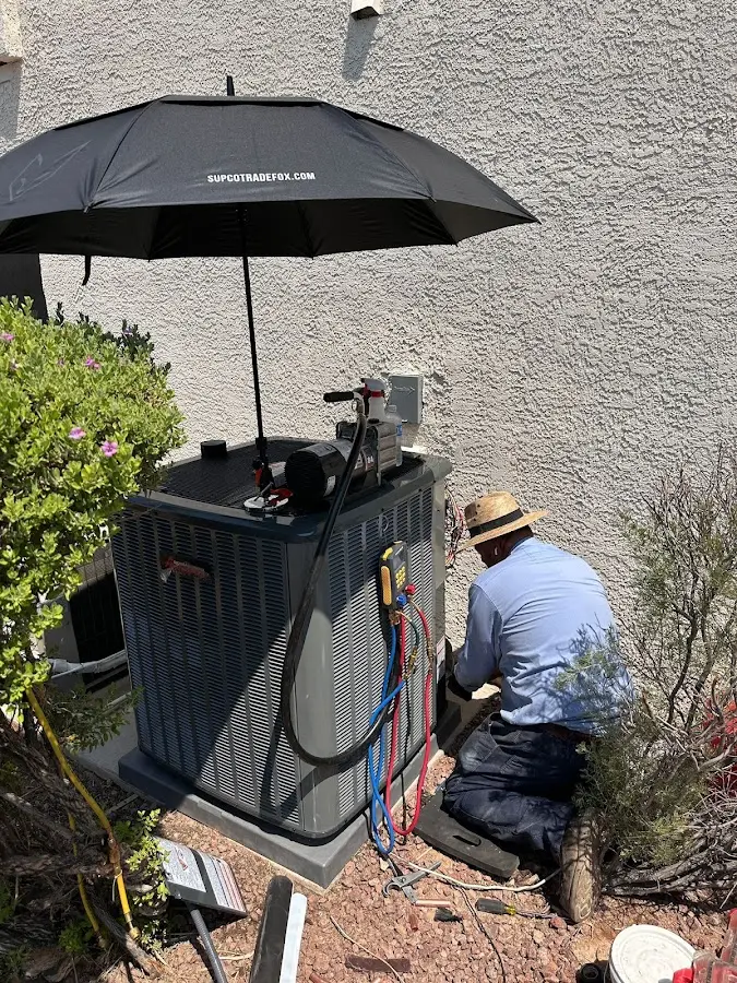 HVAC technician performing outdoor AC maintenance in Greensboro